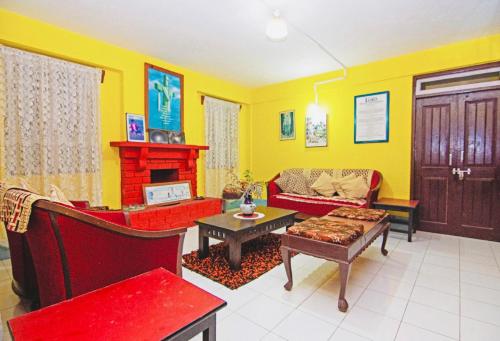 a living room filled with furniture and a fireplace at Dew Drop Homestay in Kalimpong