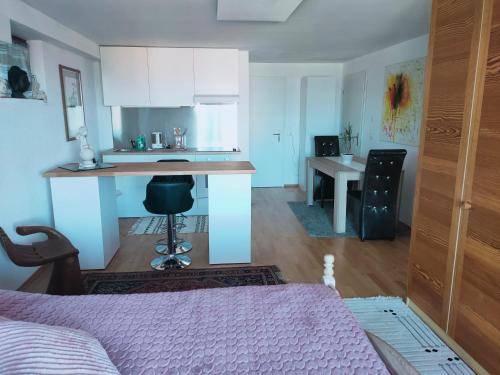 a room with a bed and a kitchen with a counter at Studio Seeblick in Rheineck