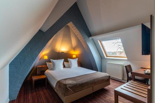 ein Schlafzimmer mit einem großen Bett im Dachgeschoss in der Unterkunft Hotel Villa Monte in Heist-op-den-Berg