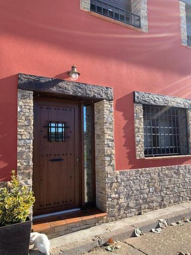 a building with a brown door and two windows at Casa el sabinar in Anchuela del Campo