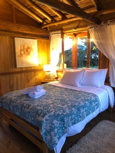 A bed or beds in a room at Cozy Log Cabin-Ojo de Agua-Villa de Leyva-WIFI