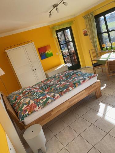 ein Schlafzimmer mit einem Bett in einem Zimmer mit gelben Wänden in der Unterkunft Ferienwohnung auf dem Kutzenberg in Altendorf
