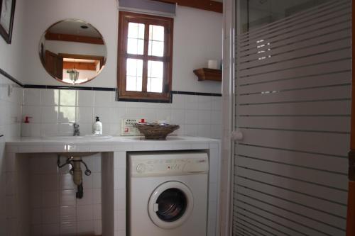un bagno con lavatrice sotto un lavandino di Appartement El Balcon ( cortijo La Cubertilla) a Fuente-Tójar