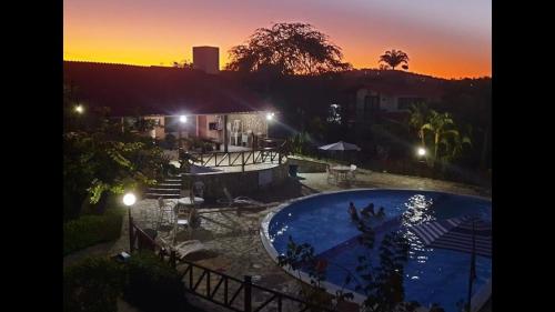 einen Sonnenuntergang über einem Pool in einem Resort in der Unterkunft Horizonte da serra 1 in Gravatá
