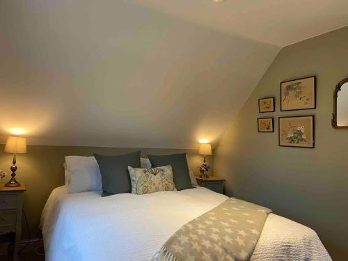 a bedroom with a white bed with pillows at Stylish getaway in the heart of the Pewsey Vale in Pewsey