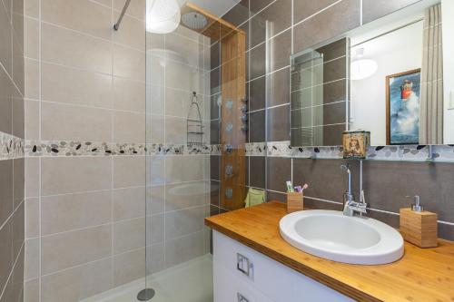 une salle de bain avec un lavabo et une douche dans l'établissement Magnifique vue sur l'océan- Appartement pour 2, à Plage-des-Demoiselles