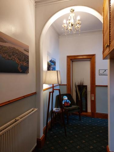 a hallway with a room with a chair and a lamp at Eddlewood Guest House in Lerwick
