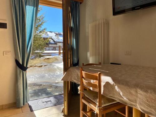 een kamer met een tafel en een raam met uitzicht bij Appartamento Piz Orsera in Livigno