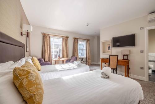a hotel room with two beds and a television at Goswell House Hotel central Windsor in Windsor