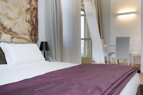 sypialnia z łóżkiem z fioletowym kocem w obiekcie Hotel Castello di Santa Vittoria w mieście Santa Vittoria dʼAlba