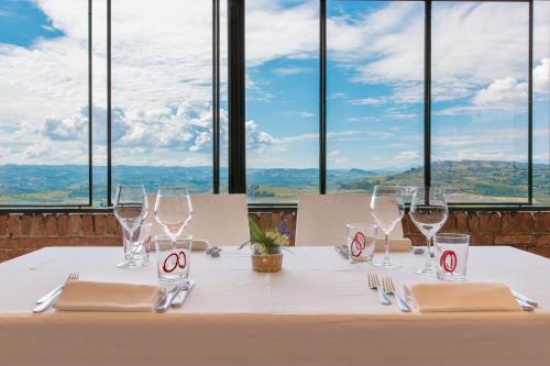 a table with wine glasses and napkins on it with a view at Hotel Castello di Santa Vittoria in Santa Vittoria dʼAlba