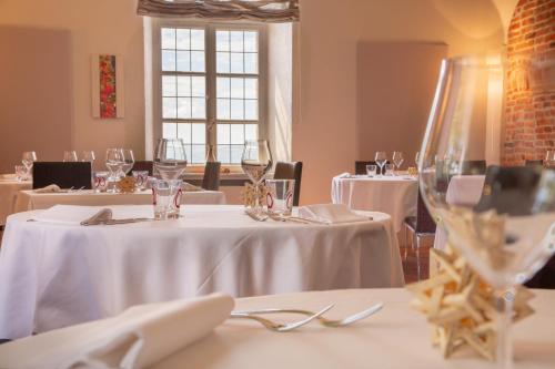 a dining room with white tables with wine glasses at Hotel Castello di Santa Vittoria in Santa Vittoria dʼAlba