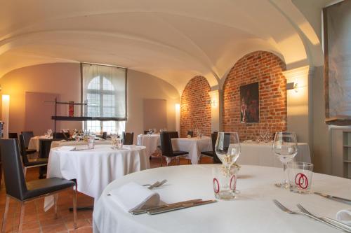 a restaurant with tables and chairs with white tablecloths at Hotel Castello di Santa Vittoria in Santa Vittoria dʼAlba