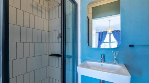 uma casa de banho com um lavatório e um espelho em Shore2Please em Cidade do Cabo