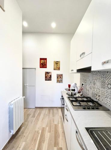 a white kitchen with white cabinets and a stove at Residenza Antico Portico in Tivoli