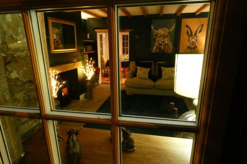 a view of a living room through a glass window at Redfearn Cottage in Apperley Bridge