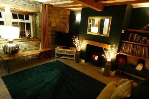 a living room with a fireplace and a television at Redfearn Cottage in Apperley Bridge