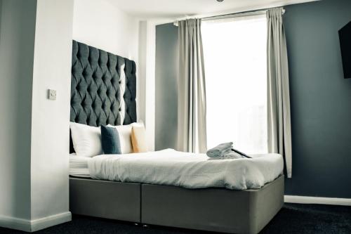 sypialnia z dużym łóżkiem i dużym oknem w obiekcie Dealhouse Apartments 10 w mieście Huddersfield