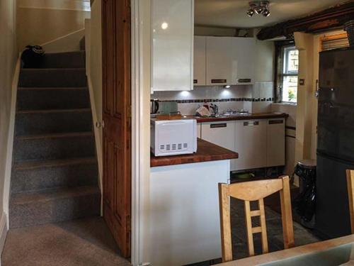 eine Küche mit einer Theke und einer Treppe darin in der Unterkunft 12 Rattle Row in Holmfirth