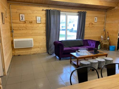 un salon avec un canapé violet et une table dans l'établissement SAINT NICOLAS LODGE, à Port-Saint-Nicolas