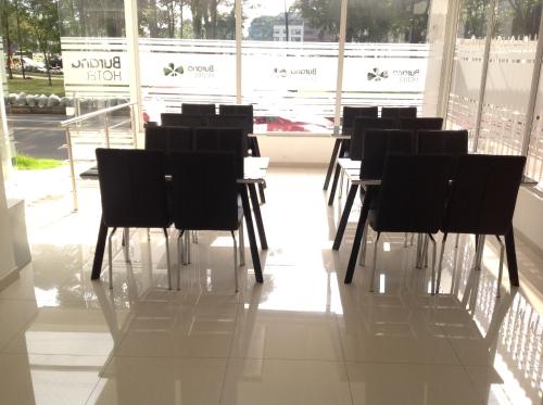a row of tables and chairs in a room with windows at Hotel Burana in Bogotá