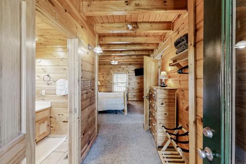 a log cabin bathroom with wooden walls and a sink at Parton Ways in Pigeon Forge