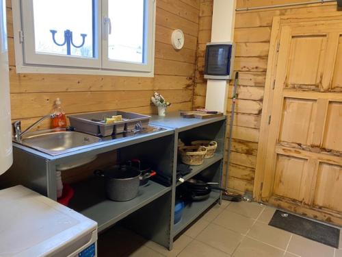 eine kleine Küche mit einem Waschbecken und einem Fenster in der Unterkunft SAINT NICOLAS LODGE in Port-Saint-Nicolas