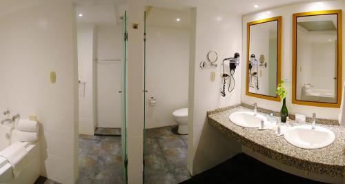 a bathroom with two sinks and a shower at Hesperia Isla Margarita in La Playa