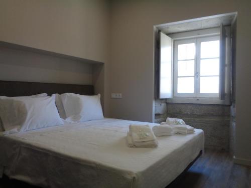 a bedroom with a bed with two towels on it at Rua Grande Hotel in Viana do Castelo