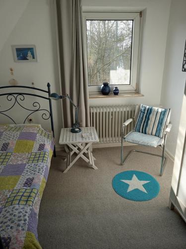 ein Schlafzimmer mit einem Bett, einem Stuhl und einem Fenster in der Unterkunft Marigold in Neumünster