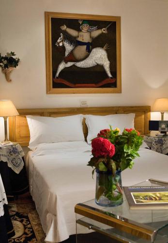 a bedroom with a bed and a painting of a woman riding a horse at Hotel Locanda Cairoli in Rome