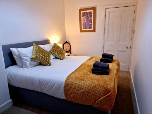 um quarto com uma cama grande com almofadas em Two Bedroom Penicuik Apartment em Penicuik