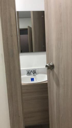a bathroom door with a sink and a mirror at OMA HOTEL LA GUAJIRA in Camarones