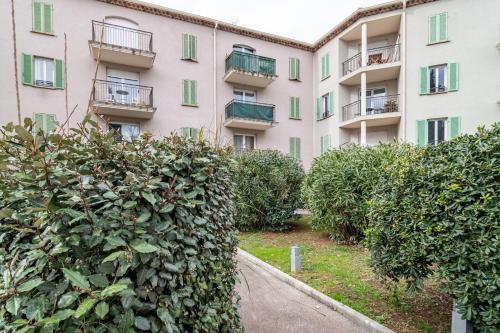an apartment building with bushes in front of it at Le Laury in Le Luc