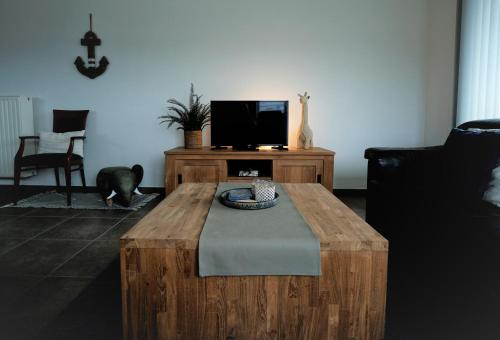 a living room with a wooden coffee table and a tv at Den Oever in Middelkerke