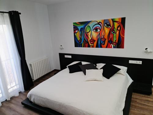 Schlafzimmer mit einem Bett mit Wandgemälde in der Unterkunft Ca la Núria in La Seu d'Urgell