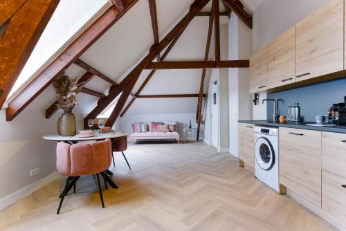 a kitchen with a table and a washer at Novallure Short Stay Apartments in Leidschendam