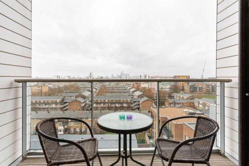 a balcony with a table and chairs and a view at Modern 1 Bedroom Apartment Near Canary Wharf with Balcony in London