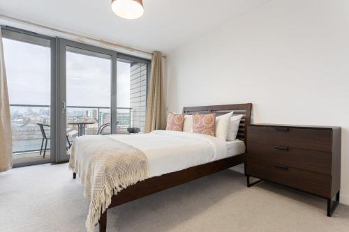 a bedroom with a large bed and a large window at Modern 1 Bedroom Apartment Near Canary Wharf with Balcony in London