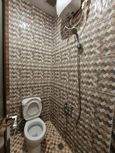 a bathroom with a toilet and a shower stall at SUPER OYO 90457 Anara Residence & Guest House in Medan
