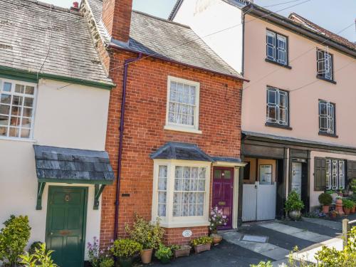 an old brick house with a green door at Garden Cottage in Ludlow
