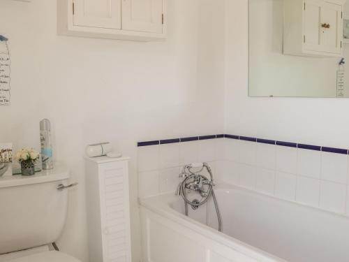 ein weißes Badezimmer mit Badewanne und Toilette in der Unterkunft Garden Cottage in Ludlow