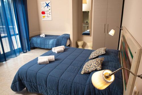 a bedroom with a blue bed and a lamp at Hostal Al Porto in San Benedetto del Tronto