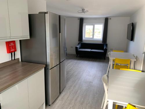 a kitchen with a refrigerator and a table and chairs at Paddington by Pureserviced in Plymouth