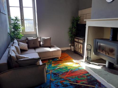 a living room with a couch and a fireplace at Le Petit Figuier in Villefranche-du-Périgord