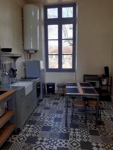 - une cuisine avec une table au milieu d'une pièce dans l'établissement Le Petit Figuier, à Villefranche-du-Périgord