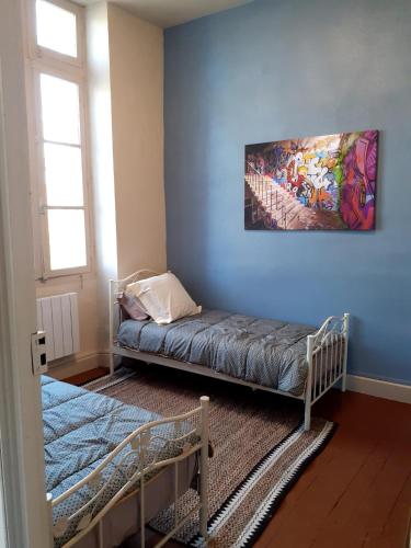 Cette chambre dispose d'un lit et d'une peinture murale. dans l'établissement Le Petit Figuier, à Villefranche-du-Périgord