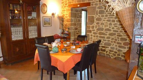 a dining room with a table and chairs in a building at Chambres d'hôtes Le Bas Rassinoux in Saint-Ouen-des-Alleux