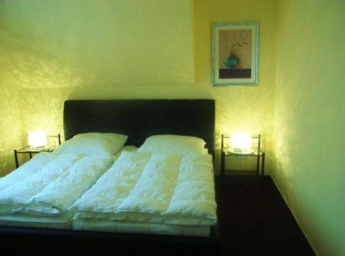a bedroom with a bed with two lamps on it at Strandresidenz-Rosengarten-Wohnung-Nr-301 in Büsum
