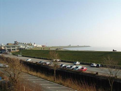 a parking lot with cars parked next to the water at Strandresidenz-Rosengarten-Wohnung-Nr-301 in Büsum